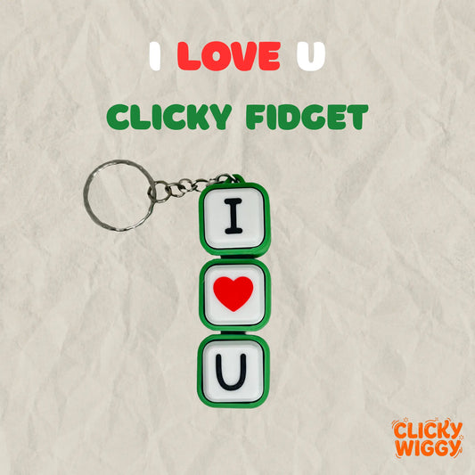 A keychain with three square white blocks outlined in green, spelling out 'I' with a black letter, 'U' with a red heart in the middle, and 'L' with a black letter. Above the keychain, text reads 'I LOVE U' and 'CLICKY FIDGET' on a beige crumpled-paper background, with the 'Clicky Wiggy' logo in the bottom right corner.