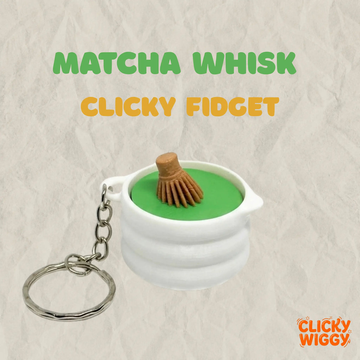 A 3D-printed matcha whisk clicker keychain is displayed on a textured beige background. The design features a white matcha bowl filled with green matcha and topped with a miniature bamboo-style whisk, along with a silver key ring attachment. Promotional text reading "MATCHA WHISK" and "CLICKY FIDGET" appears alongside the product, highlighting its matcha-inspired design and satisfying tactile click feature.